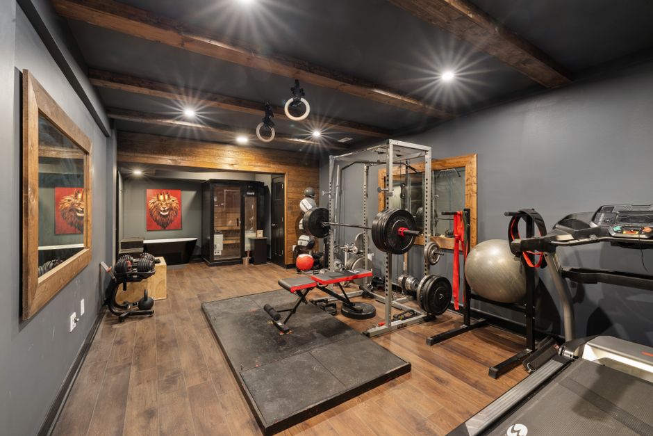 A modern home gym setup with weights, treadmill, and fitness equipment.